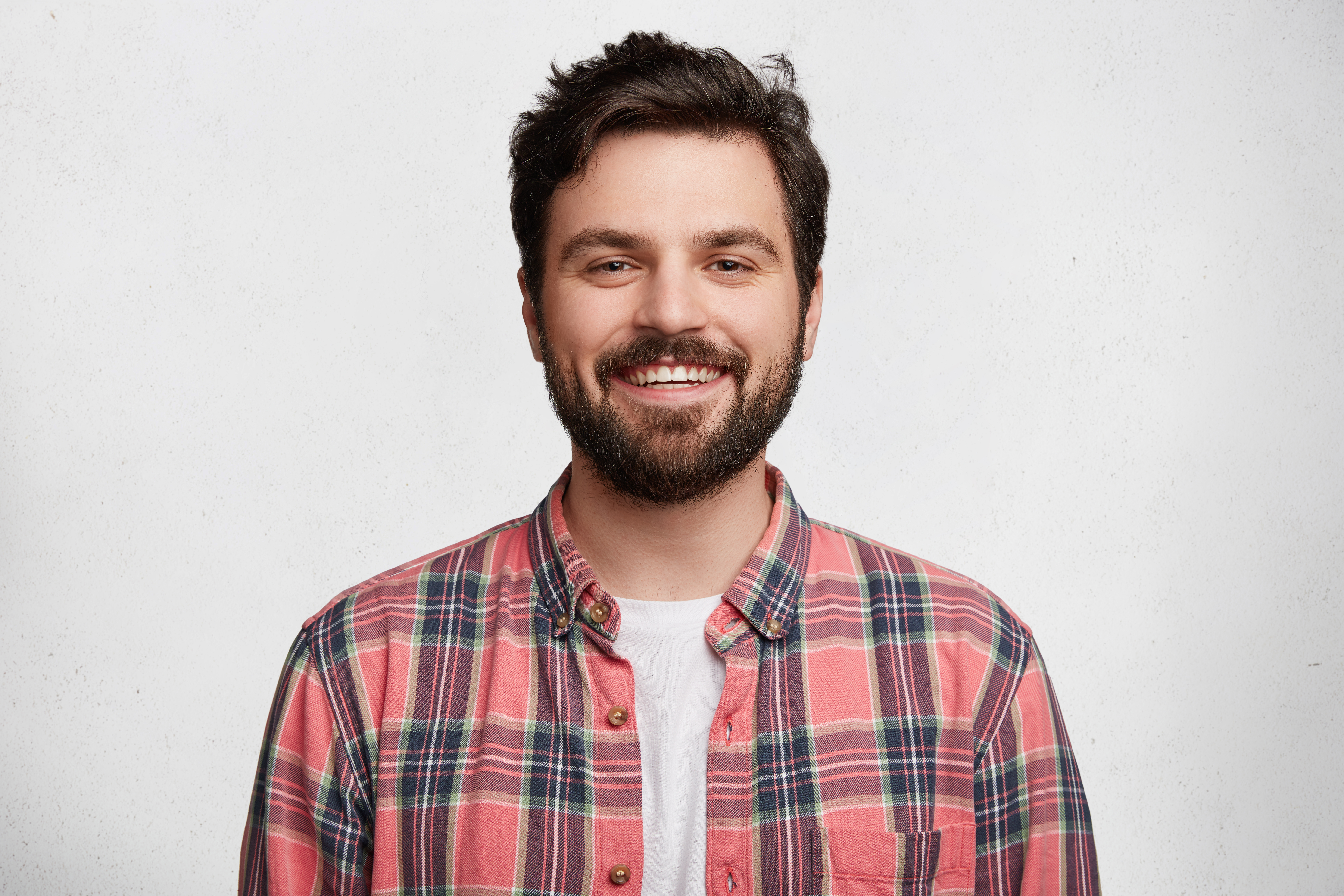 Foto de um cliente, jovem barbudo sorridente